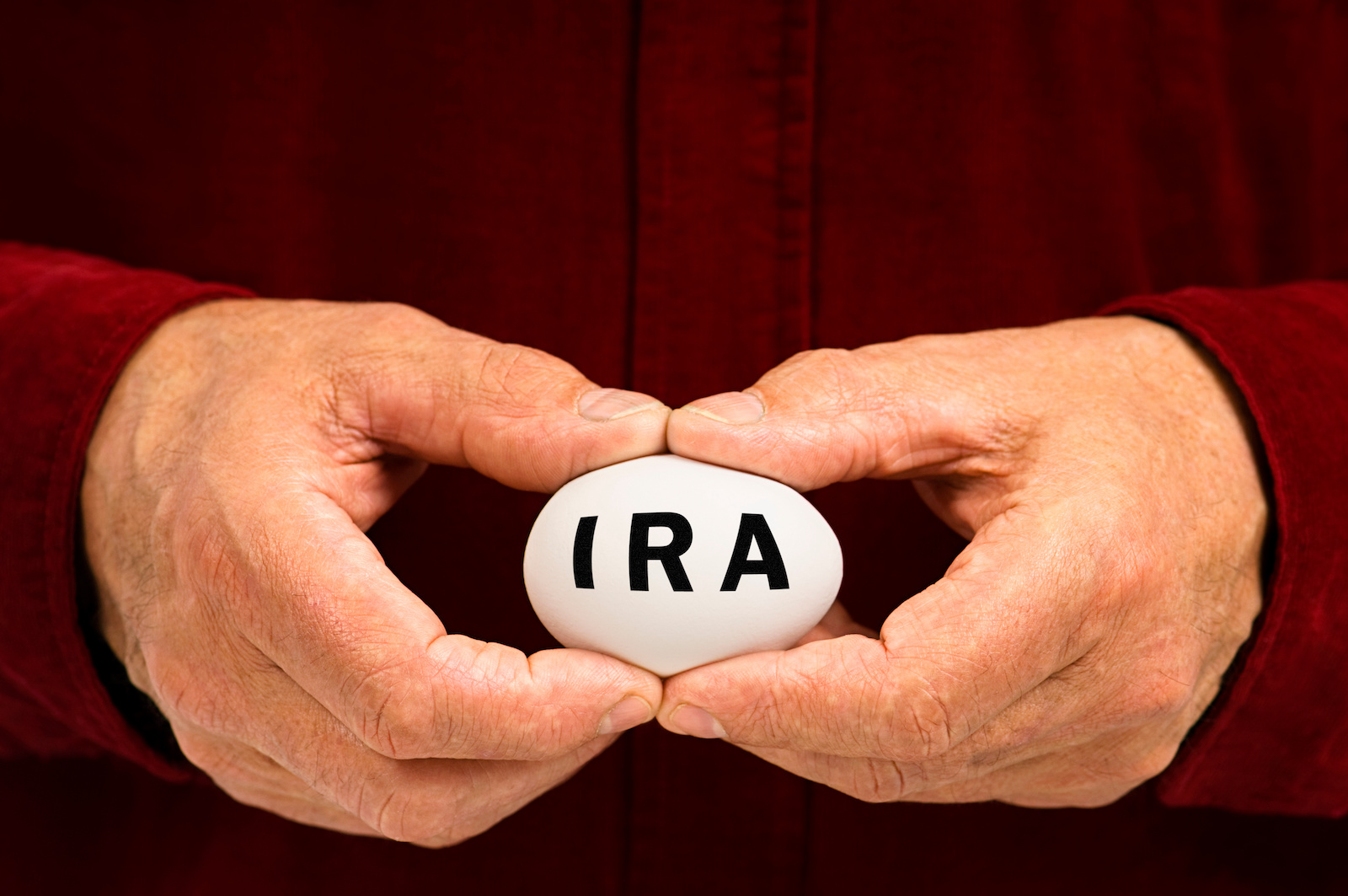 Man holds white egg with IRA written on it SECURE 2.0